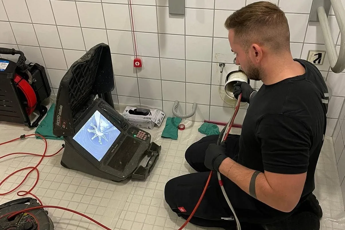 Techniker von P&N bei der Kamerainspektion einer Abwasserleitung im Sanitärraum